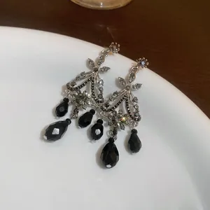Elegant vintage silver-toned dangle earrings featuring faceted black teardrop beads and stones.