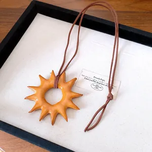 Vintage sun-shaped wooden pendant necklace with adjustable brown cord for women.