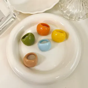 Collection of five colorful round resin rings artfully displayed on a white plate.