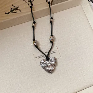 Macro view of a vintage silver hammered heart pendant necklace with black cord