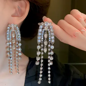 Close-up of shimmering long rhinestone tassel earrings showing elegant draping effect.