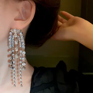 Close-up of long silver tassel earrings with sparkling rhinestones for an elegant look