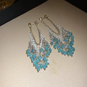 Teal glass teardrop tassel dangle earrings with gold and silver tone accents