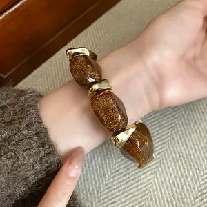 Detailed close-up view of a chunky brown glitter acrylic beaded bracelet worn on a wrist