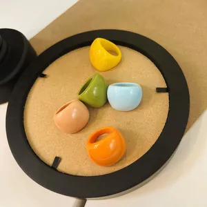 Macro view of colorful chunky resin rings in yellow, green and orange on cork background