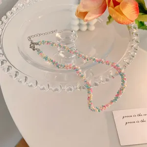 Detail view of colorful hand-woven seed bead necklace placed on a decorative glass tray