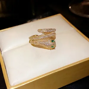 Gold plated zircon snake open ring with green stone eyes on luxury jewelry box