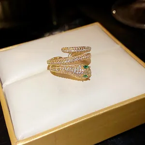 Close-up of a gold-plated snake-shaped open ring with cubic zirconia on a jewelry box.