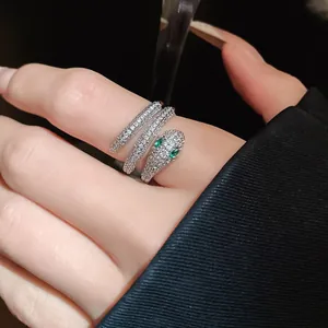 Detailed close-up of a silver snake wrap ring with sparkling crystals and green eyes