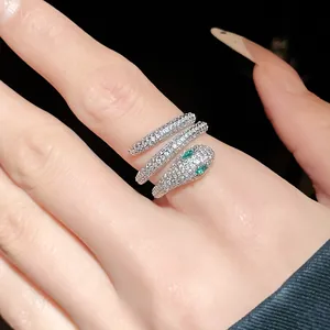 Macro detail of a sparkling silver-plated snake wrap ring with green zircon eyes.