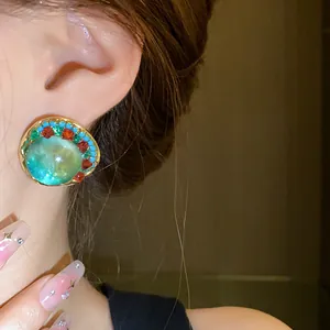 Vintage palace style green round earrings with colorful crystal accents shown on ear