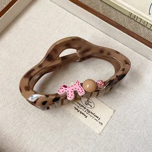 Chic leopard print hair claw clip featuring a cute pink dog and rhinestone accent