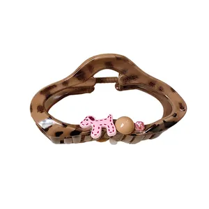 Chic leopard print hair claw clip featuring a cute pink dog and sparkling rhinestone detail