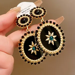 Detail view of vintage palace style oval earrings with gold starburst motif