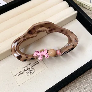 Close-up of leopard hair claw clip with pink dog and beads in jewelry tray