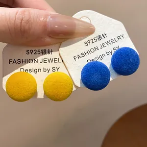 Primer plano de pendientes redondos amarillos y azules con agujas de plata S925