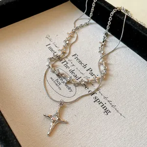 Primo piano di una collana d'argento a strati con pendenti a stella e cristalli.