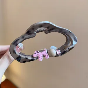 Detailed close-up of leopard print hair claw clip featuring pink puppy and crystal bead