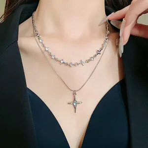Collana a doppio strato in argento con stella e croce su modella.