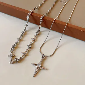 Dettaglio di due collane d'argento con stelle e croci e cristalli scintillanti