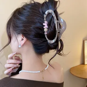 Detailed view of a leopard print hair claw clip with cute puppy charm on an elegant updo