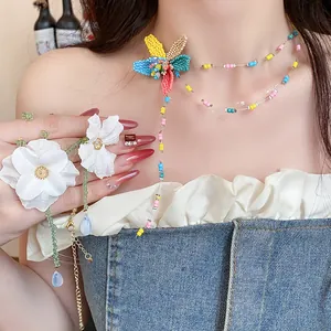 Dettaglio della collana di perline colorate e del fiore in tessuto fatto a mano su modella