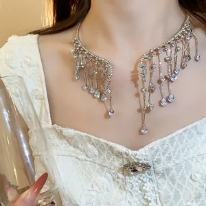 Detail of an elegant silver rhinestone waterdrop tassel choker necklace on a model.