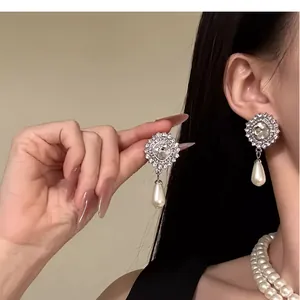 Detailed view of vintage French pearl teardrop earrings and layered pearl necklace
