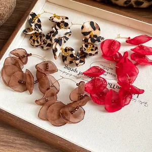 Detail of fabric flower hoop earrings in leopard print, brown and red sheer styles