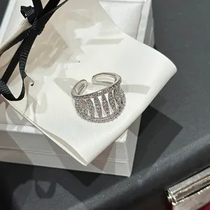 Close-up of elegant silver-toned hollow open ring with sparkling pavé zircon stones