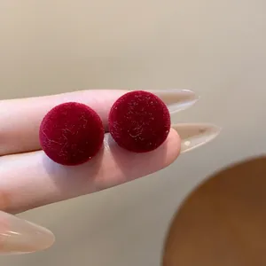 Primer plano macro de pendientes redondos aterciopelados rojos con textura suave