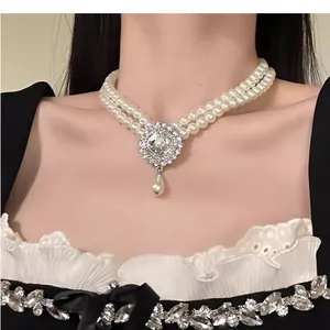 Detailed view of a French vintage double-strand pearl necklace with a rhinestone pendant.