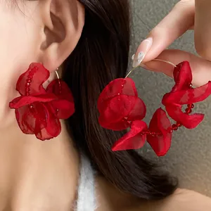 Detailed macro shot of elegant red fabric flower hoop earrings with delicate beads
