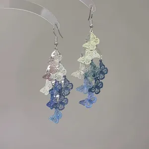 Close-up of elegant hollow butterfly drop earrings with multi-color gradient design