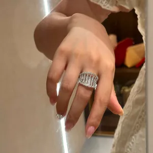 Detailed view of an elegant silver hollow ring with sparkling zircons on a finger