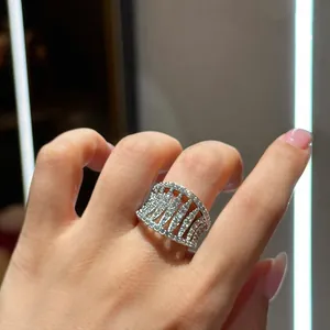 Close-up of an elegant zircon hollow open ring on a finger with sparkling details.