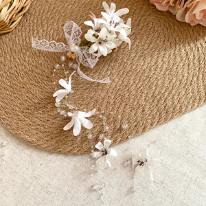 Macro view of Mori-style floral hair clip with white lace bow and long bead tassels