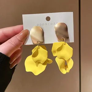 Primo piano dettagliato che mostra i petali di rosa gialli opachi di questi orecchini moda