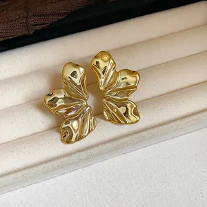 Vista detallada de elegantes pendientes dorados con textura de hoja en joyero