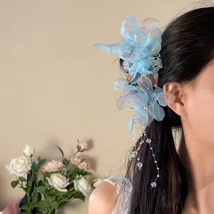 Detail view of a Mori style blue mesh flower hair clip with pearl tassels worn by a model.