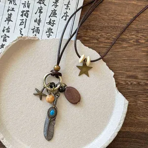 Gros plan d'un collier ethnique rétro avec pendentifs plume et perles en bois