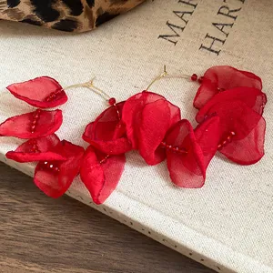 Detailed macro view of stylish red fabric petal hoop earrings with elegant bead accents.