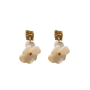 Fashionable white floral earrings with textured gold square studs and silver needles