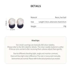 Detail view of round resin stud earrings with white hair balls and size specifications