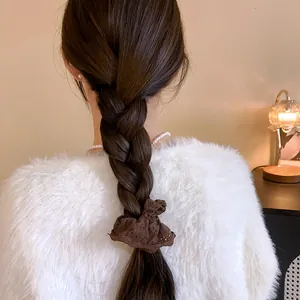 Close-up showing a brown floral eyelet lace scrunchie on a classic braided ponytail