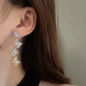 Close-up detail of elegant silver needle zircon butterfly tassel earrings on model ear