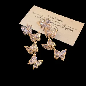 Detailed view of elegant gold butterfly tassel earrings with sparkling clear zircon crystals