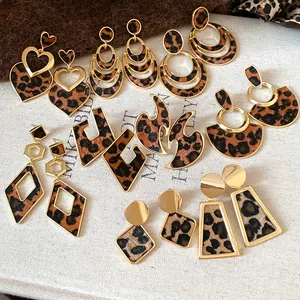 Detailed view of various leopard print earrings with gold-toned metal frames and textures.