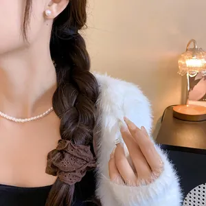 Close-up of a brown hollow lace scrunchie on a low ponytail French style hair accessory