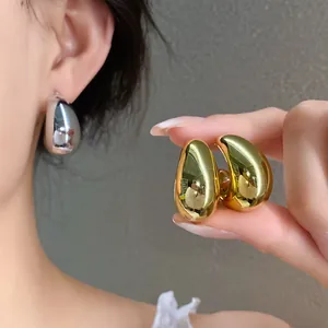 Primer plano de alta calidad de pendientes de gota gruesos en oro y plata